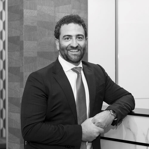 Dr Andrew Hadj standing in a cosmetic surgery clinic in Brisbane