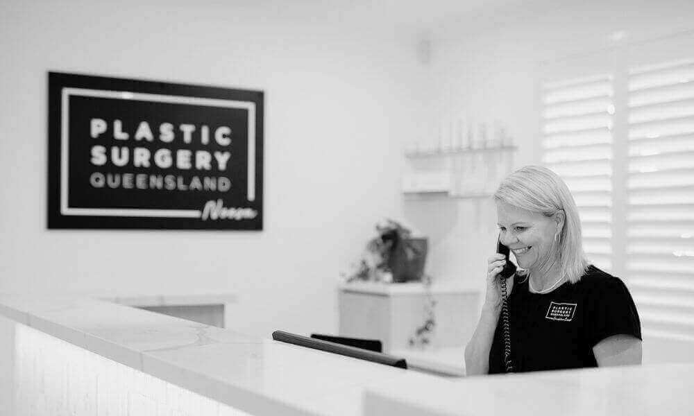 Receptionist at plastic surgery clinic in Noosa discussing a boob job procedure with a client