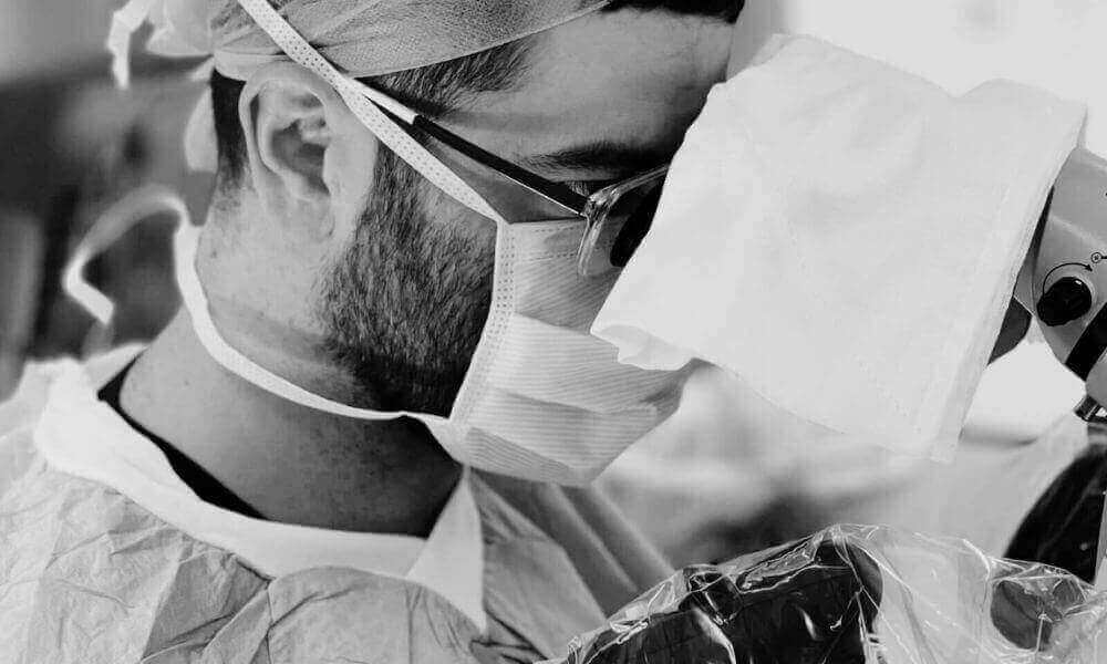 Surgeon looking at skin cancer cells under a microscope