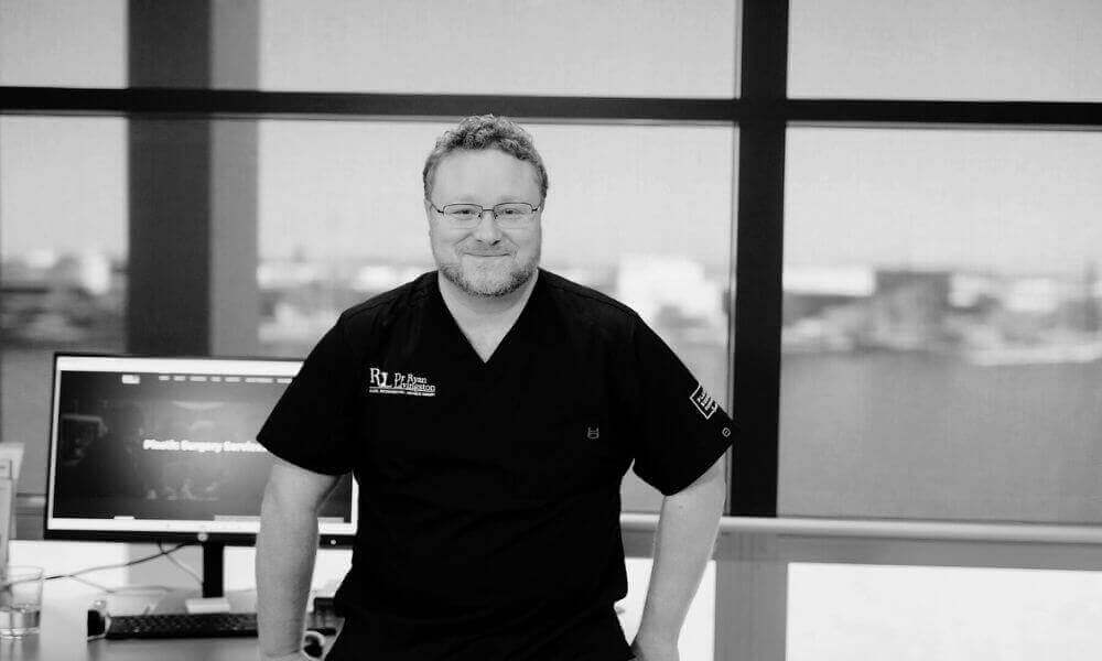 Reconstructive surgeon smiling at camera inside Plastic Surgery Queensland's clinic on the Gold Coast